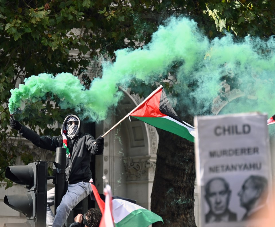 A pro Palestine support holding a flare during the Palestinial rally in Whitehall. picture David Dyson