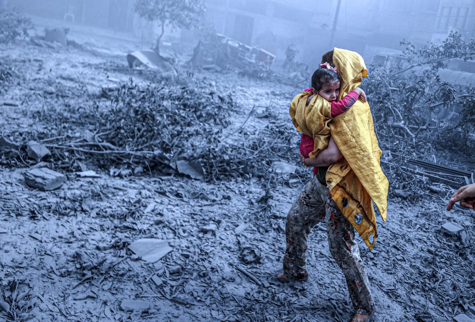 GAZA CITY, GAZA - OCTOBER 23: A woman holding moves amid damage after Israeli airstrikes hit Ridwan neighborhood of Gaza City, Gaza on October 23, 2023. (Photo by Ali Jadallah/Anadolu via Getty Images)