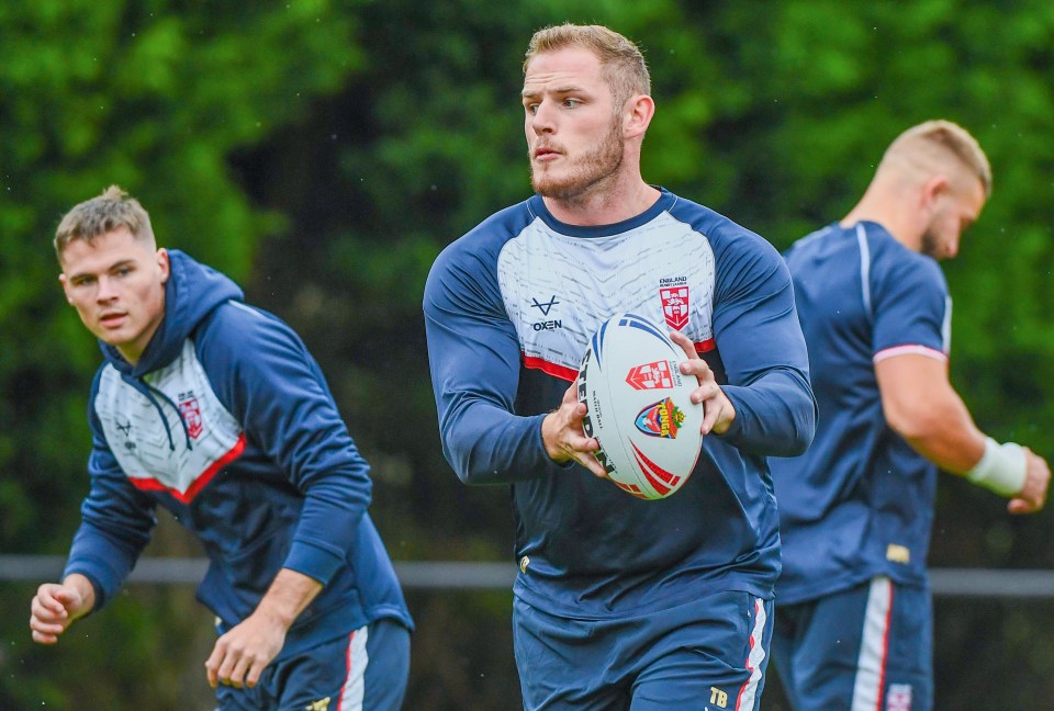 England rugby league player holding a rugby ball during training.