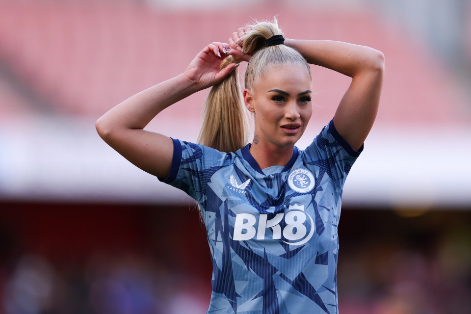 a woman in a bk8 jersey adjusts her hair