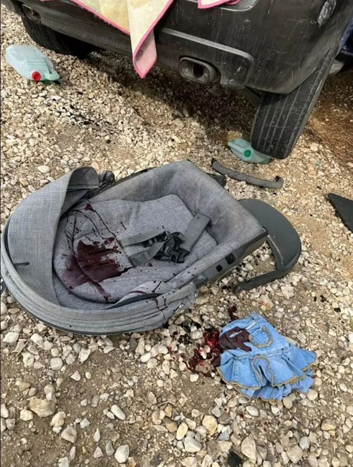 A baby’s car seat and child’s dress is seen covered in blood in the aftermath of the horrific Hamas attack