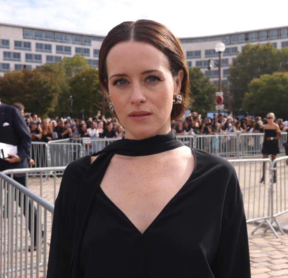 a woman wearing a choker and earrings stands in front of a crowd