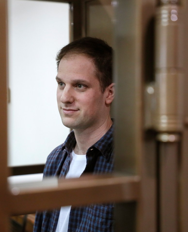 The jailed reporter put on a brave smile behind his glass cage