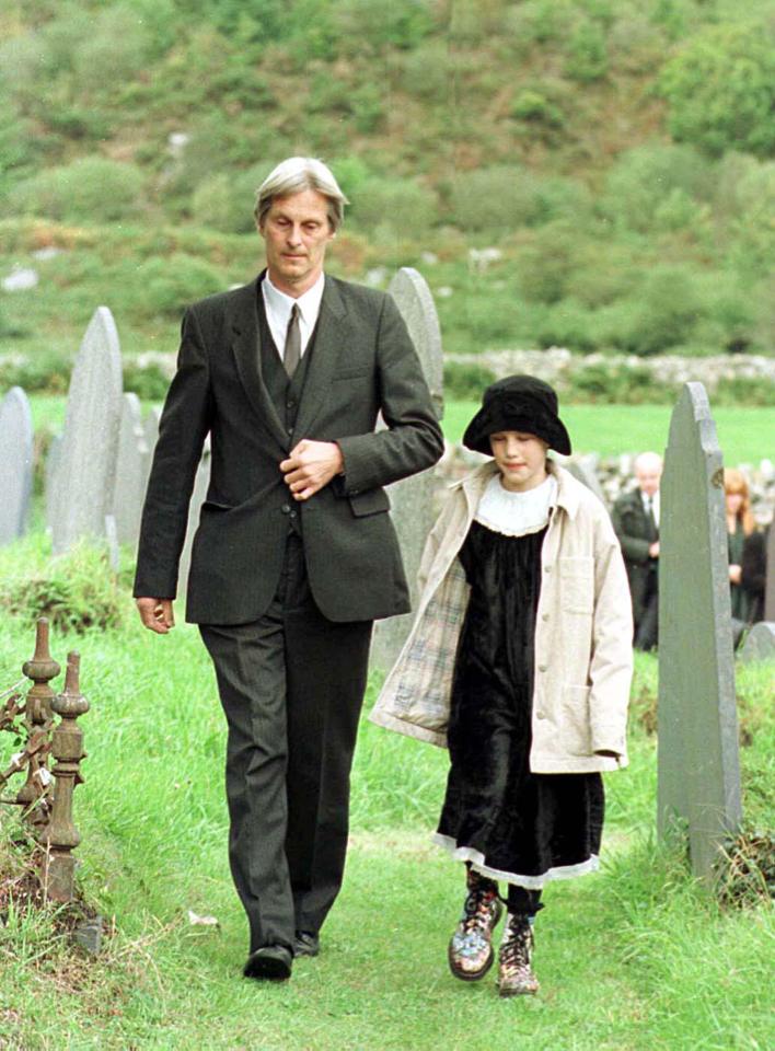 Dr Shaun Russell and his daughter Josie walk away from the graveside following the funeral of Lin and Megan Russell