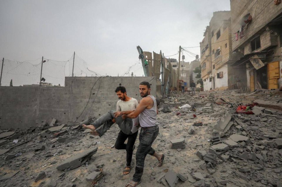 A civilian is carried to help after being wounded in an air strike