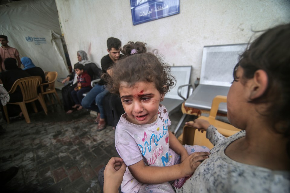 An injured child waits outside of a hospital in Gaza