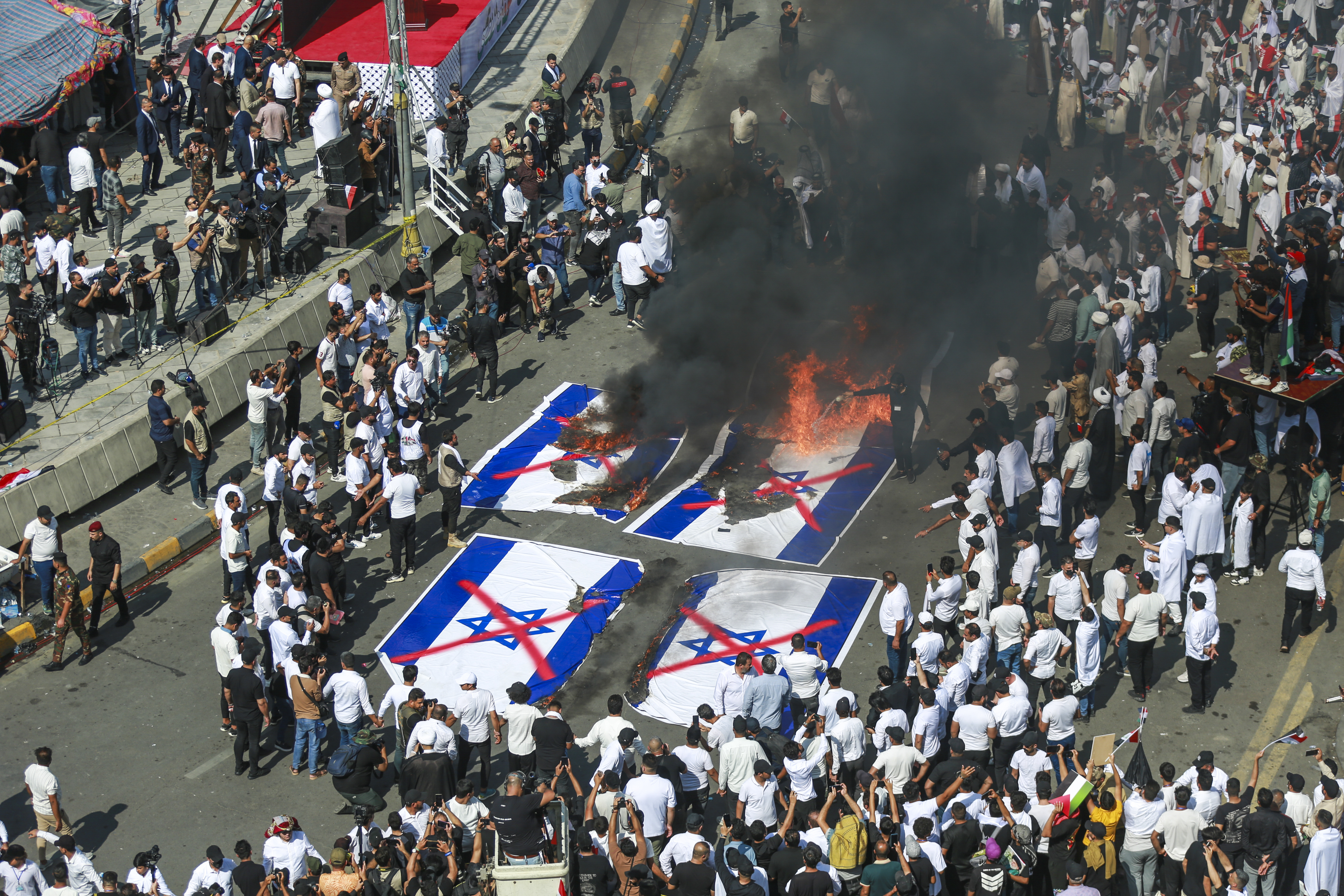 Iraqis burn Israeli flags during a mass rally in support of the Palestinians