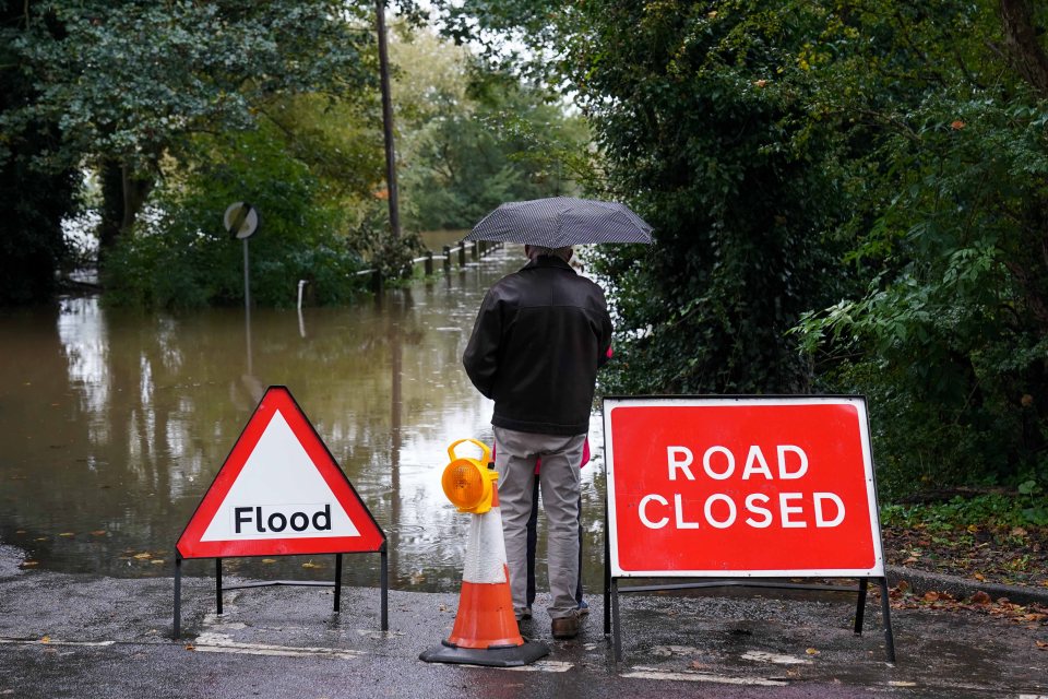 Local residents observe the flooded Carlton Ferry Lane in the village of Collingham in Nottinghamshire