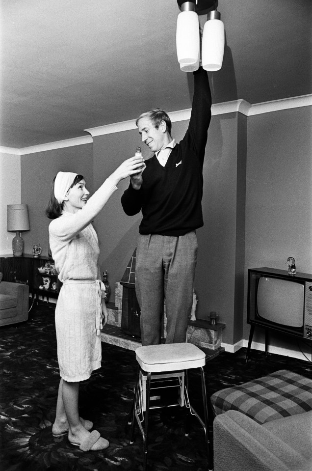 a man and a woman are standing in a living room