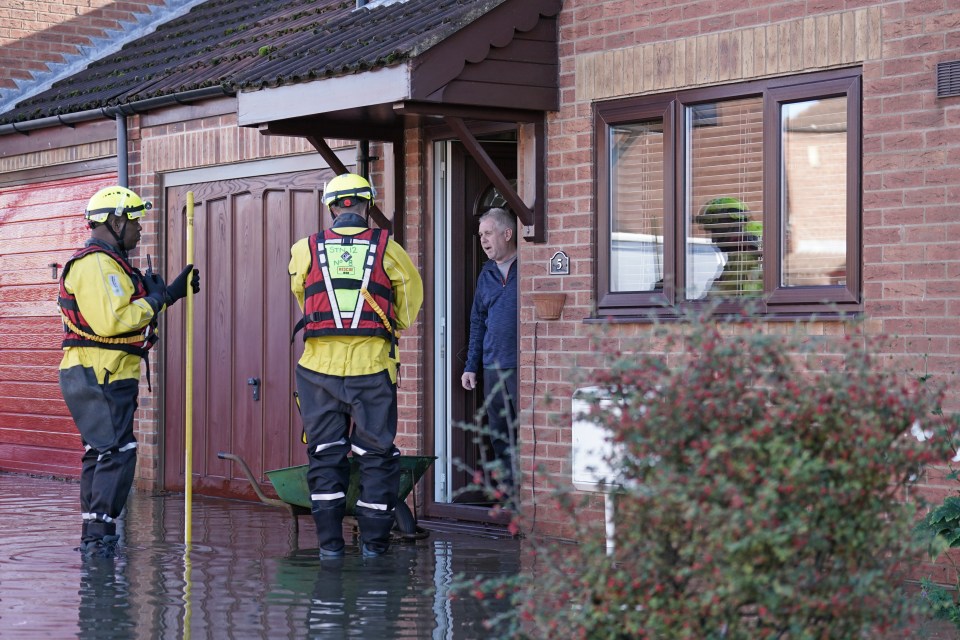 Members of the emergency services talk to residents in Retford after Storm Babet