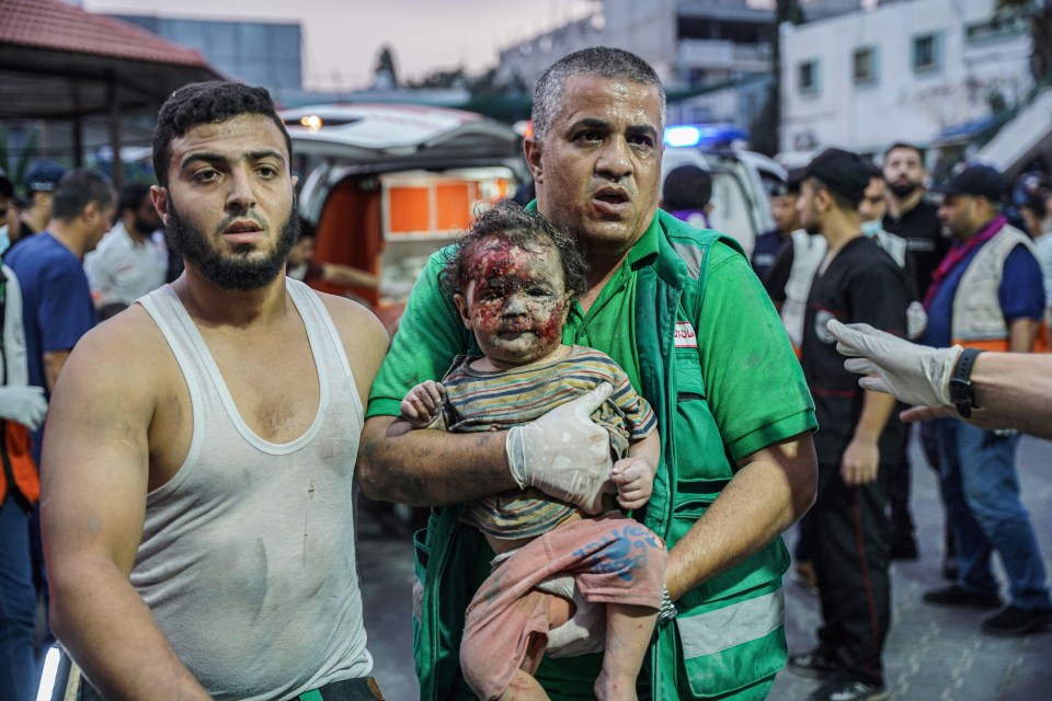 A paramedic holds a girl after bombing in Gaza as part of Israel’s revenge attacks