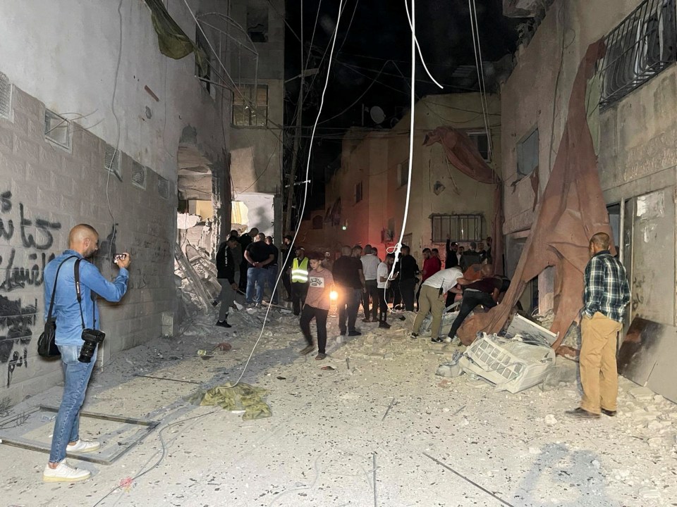 People inspect the damage after an Israeli strike hit a compound beneath a mosque in the occupied West Bank