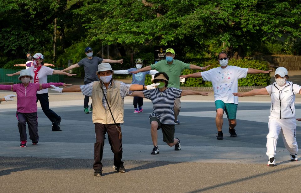 People taking part in a morning radio taiso exercise at a park in Tokyo