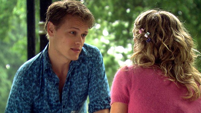 a man in a blue shirt talks to a woman in a pink shirt