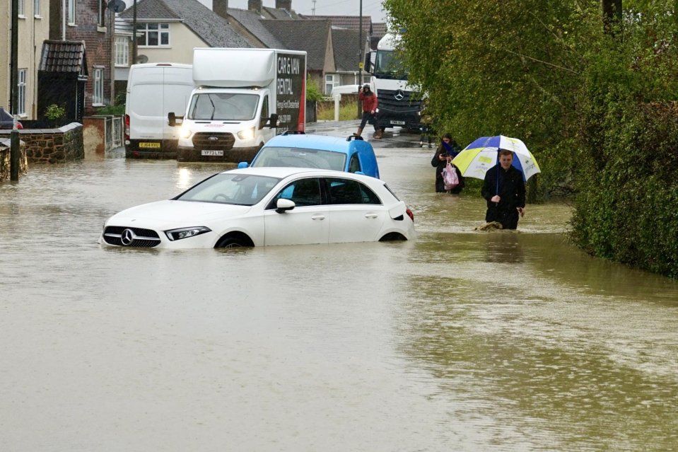 A man wades past a stranded car in Chesterfield