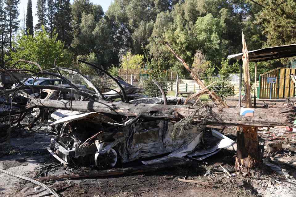 A damaged car and fallen tree after a rocket attack from southern Lebanon on the Israeli city of Kiryat Shmona