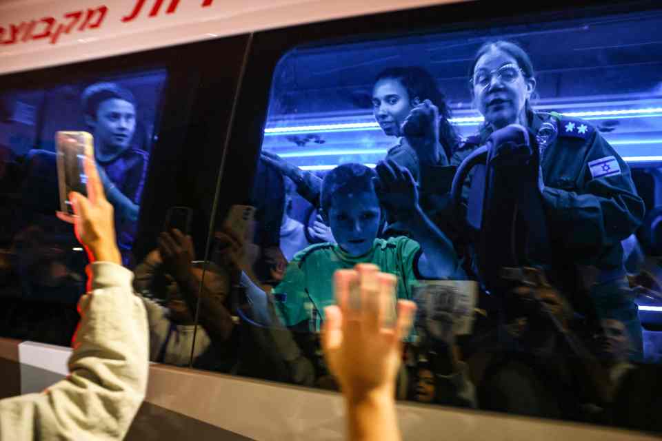 Hostages released by Hamas stand in a bus transporting them to an army base in Ofakim in southern Israel