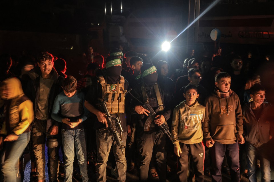 Children stand alongside Hamas fighters as the latest group of hostages are finally freed