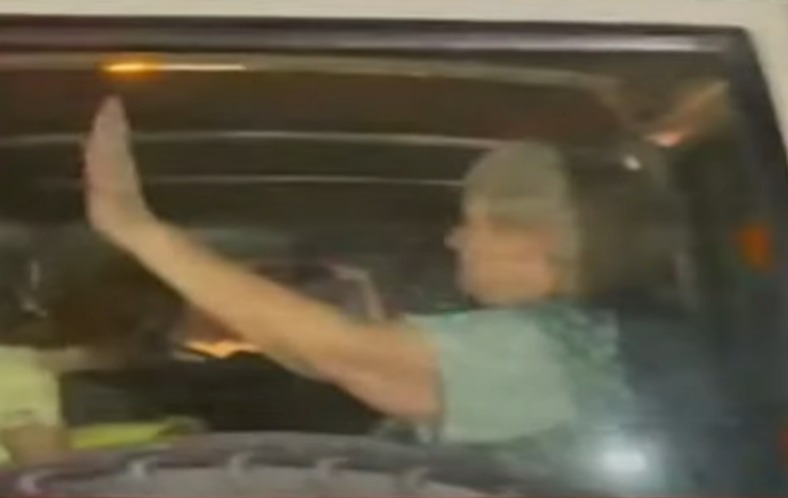 One woman, believed to be a hostage, is seen waving to the crowds gathered at the crossing