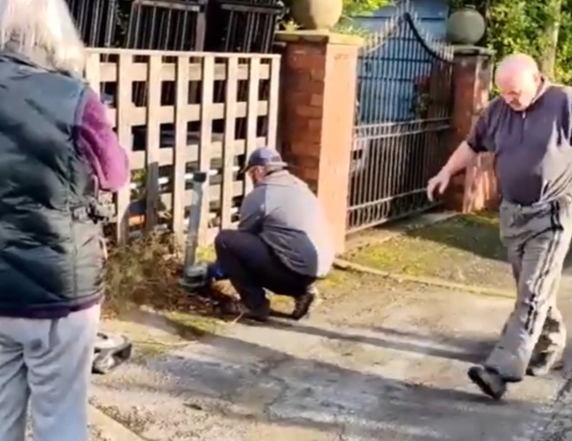 This is the shocking moment a man uses an angle grinder to cut down a metal fence