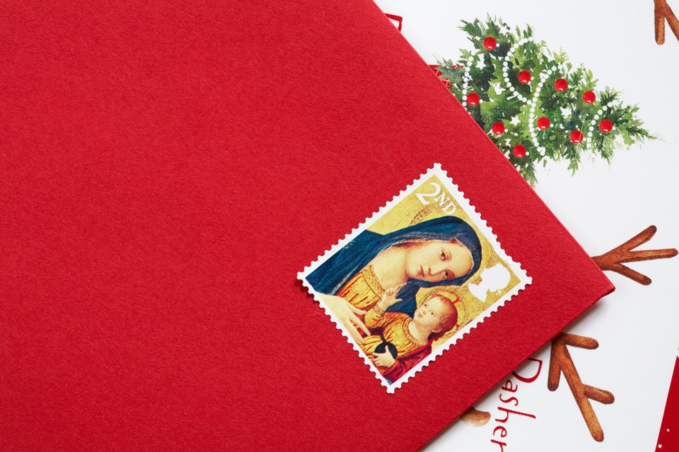 CMM6C0 UK 5 November 2013. With only 49 days to Christmas the Christmas stamps are released in the UK - 2nd class Christmas stamp with Madonna and child stuck on rred envelope. Credit: Carolyn Jenkins/Alamy Live News