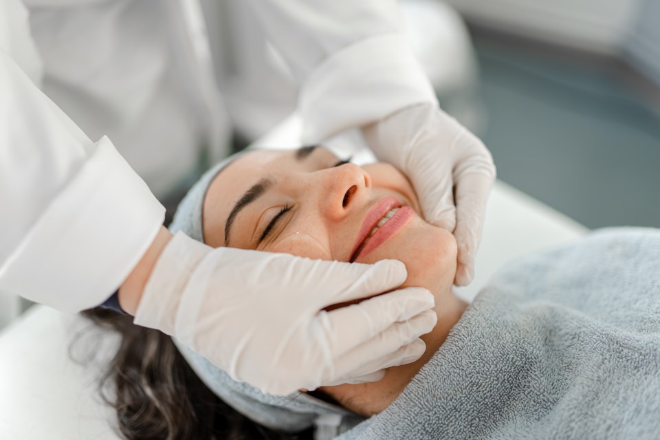 Happy woman receiving a beauty treatment.