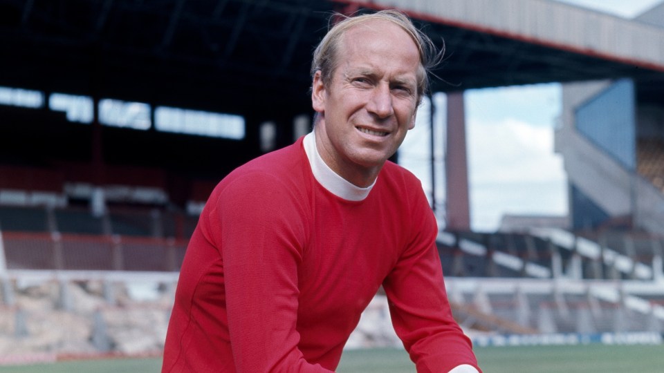 a man in a red shirt stands on a soccer field