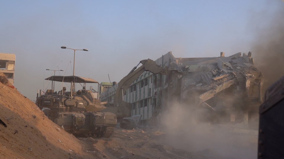 Israeli military bulldozer demolishes a building inside the Gaza Strip