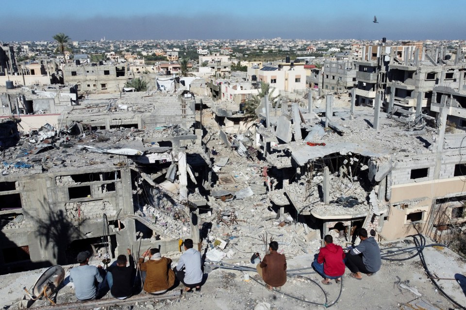 Palestinians look out at the rubble and ruin of Gaza