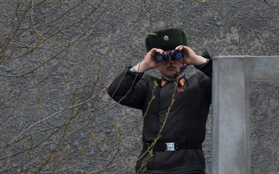 A North Korean soldier looking across the Yalu river opposite the Chinese border city of Dandong