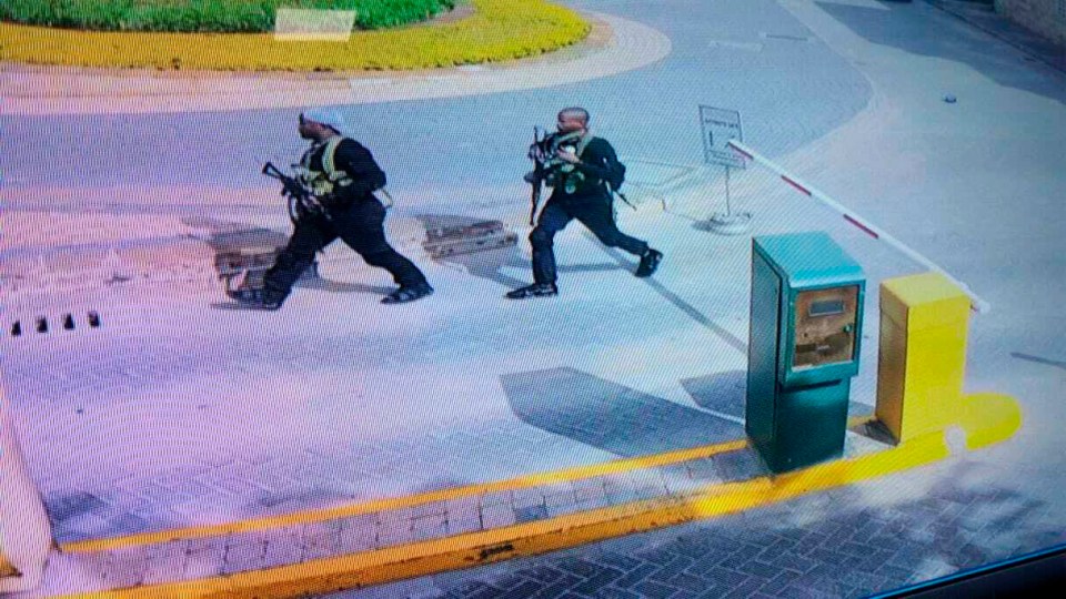 Heavily armed attackers walk in the compound of the hotel in 2019