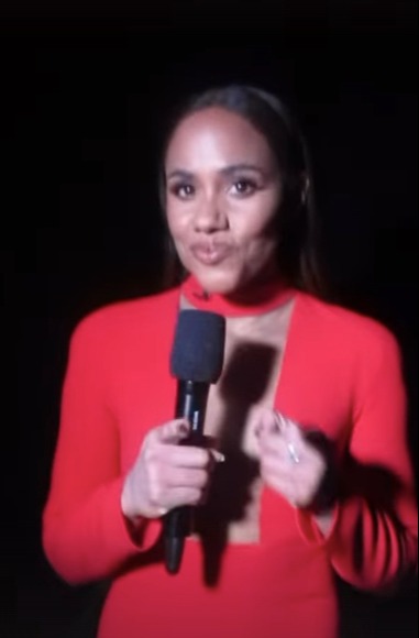 a woman in a red dress is holding a microphone .