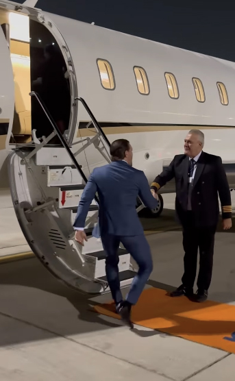 McGregor boards the jet in a stylish blue suit