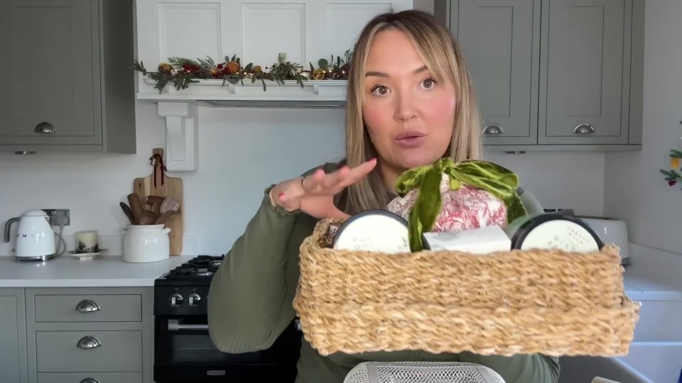 Woman holding a gift basket of Poundland items transformed into expensive-looking presents.