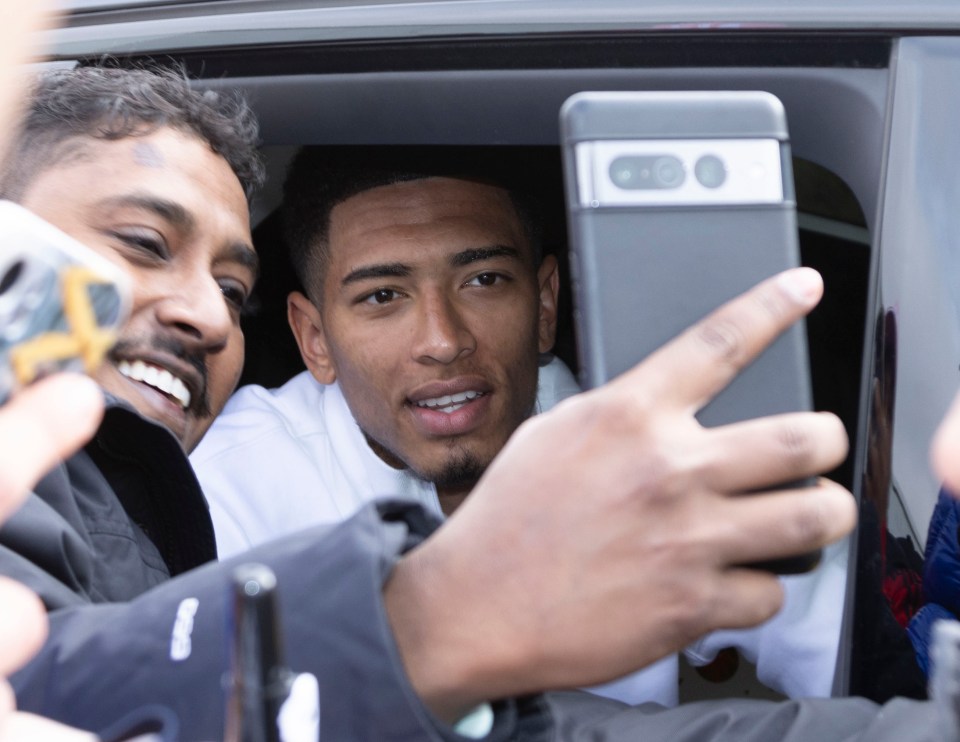 Sun feature -Jude Bellingham in Real Madrid. Real Madrids Jude Bellingham is driven from their training ground by his mum. ( he is in the back seat, the passenger in the front is unknown) .Jude winds down the window to sign autographs and shirts for waiting fans