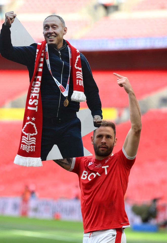 Steve Cook holds aloft a cardboard cutout of Steve Cooper at Wembley after Nottingham Forest won promotion in the play-off final