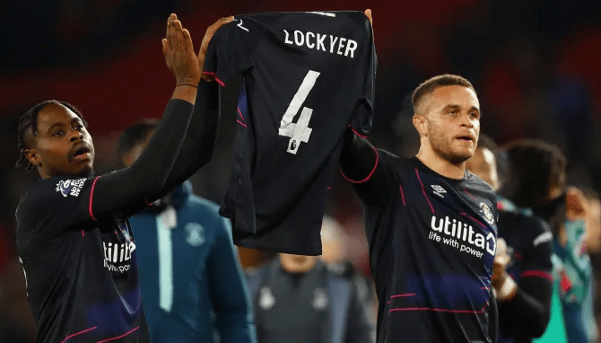 Pelly Ruddock Mpanzu, left, and Carlton Morris, right, holding Lockyer’s shirt up to the fans