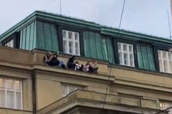 Terrified students were seen clinging onto the roof ledge after the gunman opened fire