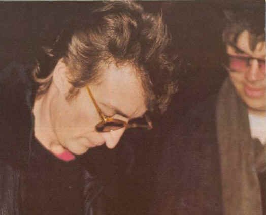 John signing a copy of his album for Mark Chapman - who, just a few hours later, would shoot dead the ex-Beatle