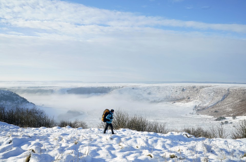 A hiker walks through snow above the Hole of Horcum in the North York Moors earlier this month