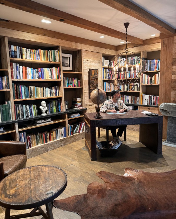 Taika posed in a large book room in the luxury villa