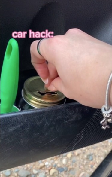 Jadyn cuts a slit in the top of the lid so she can pop coins into the jar