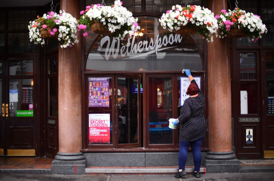 An employee makes the finishing touches at the reopening of the Rochester Castle pub following lockdown restrictions easing