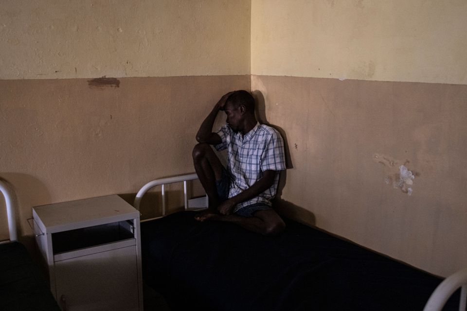 A recovering Kush addict sit on his bed at the Kissy Mental Hospital in Freetown