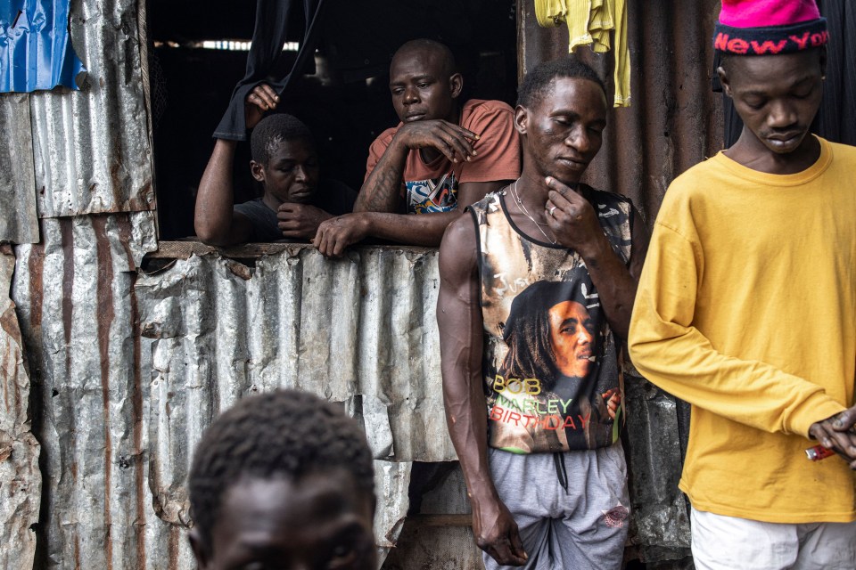 People gather in a Kush drug den in Freetown on June 26, 2023