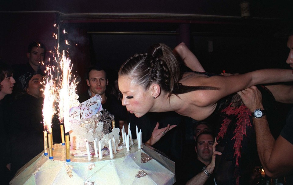 Kate Moss pictured blowing out candles on a cake at a party held for her 29th birthday after the Versace fashion shows in Paris.