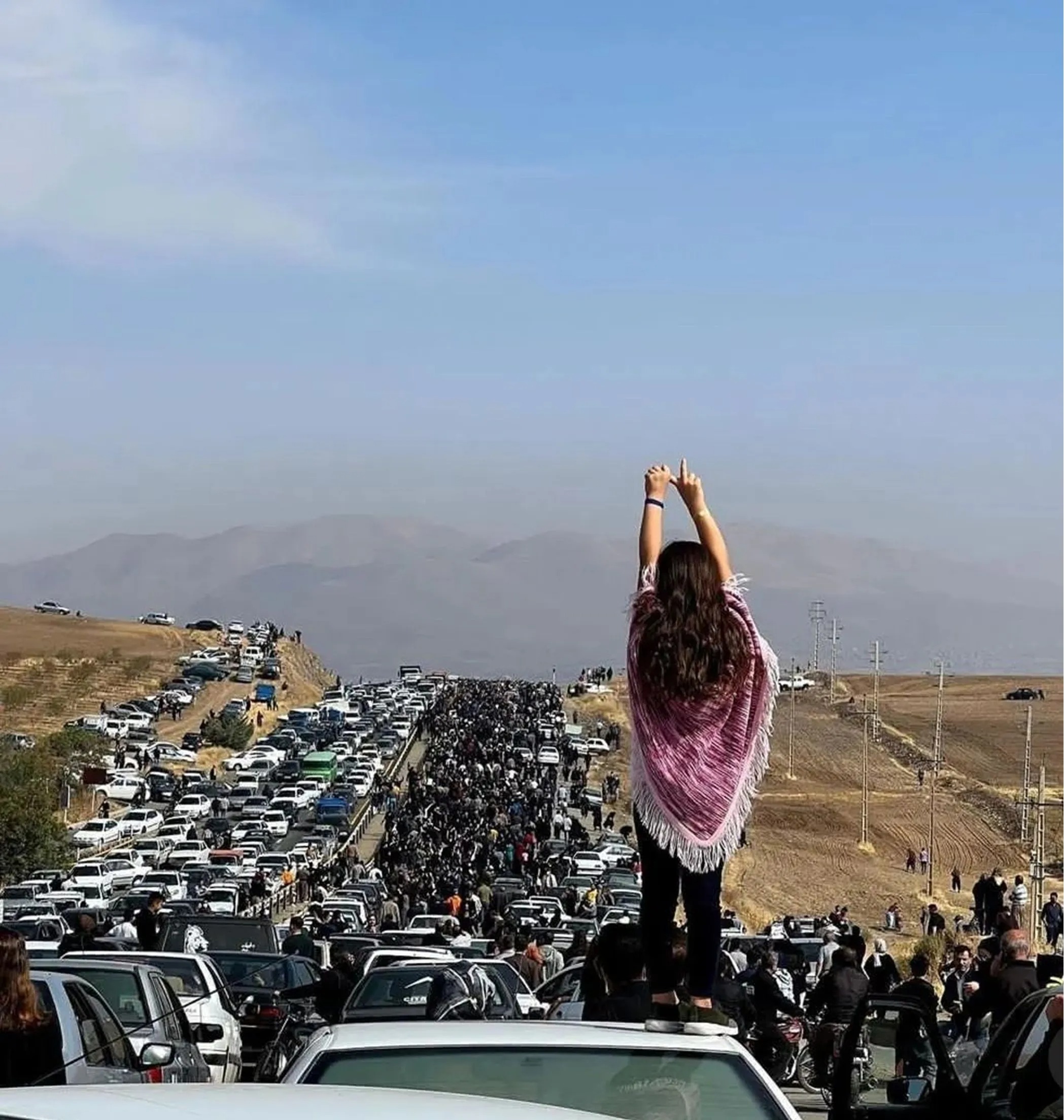 A woman with open hair protesting against Iran's theocratic regime following Mahsa Amini's death