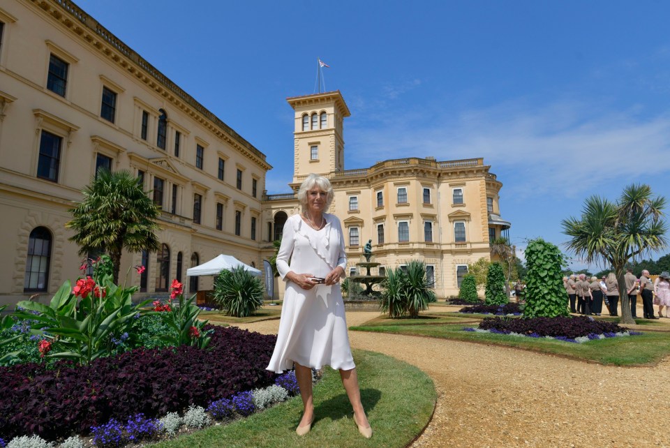 Queen Camilla in front of the Italian-style clock tower on a 2018 visit