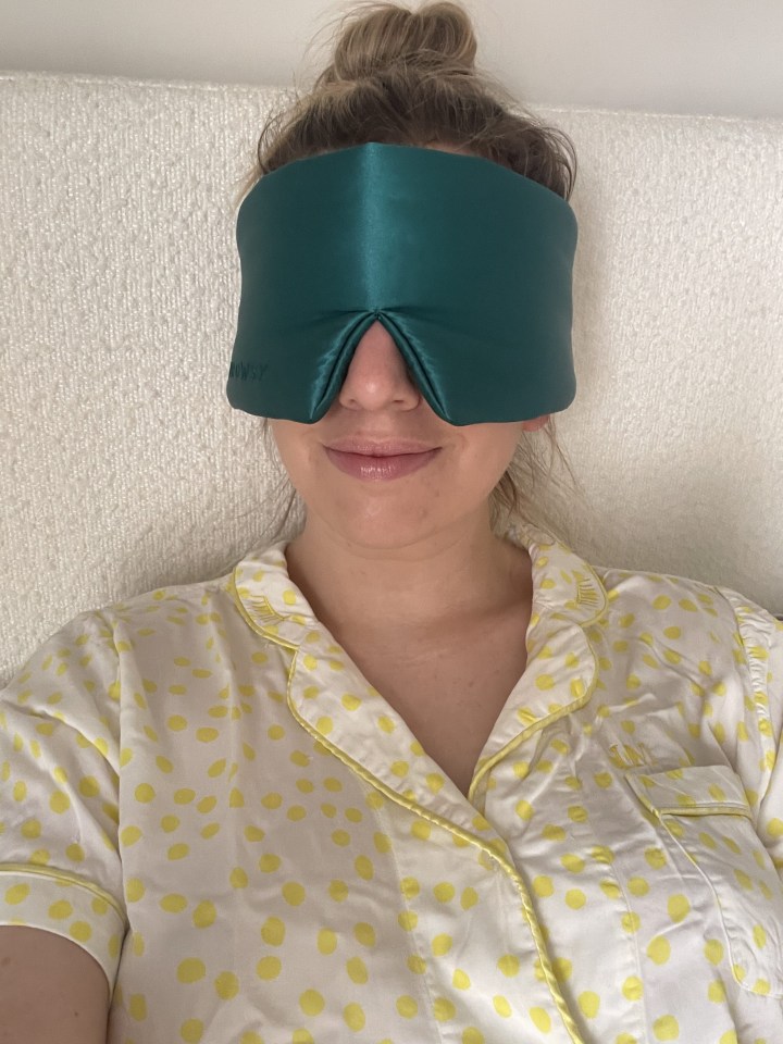 Woman wearing a green sleep mask.