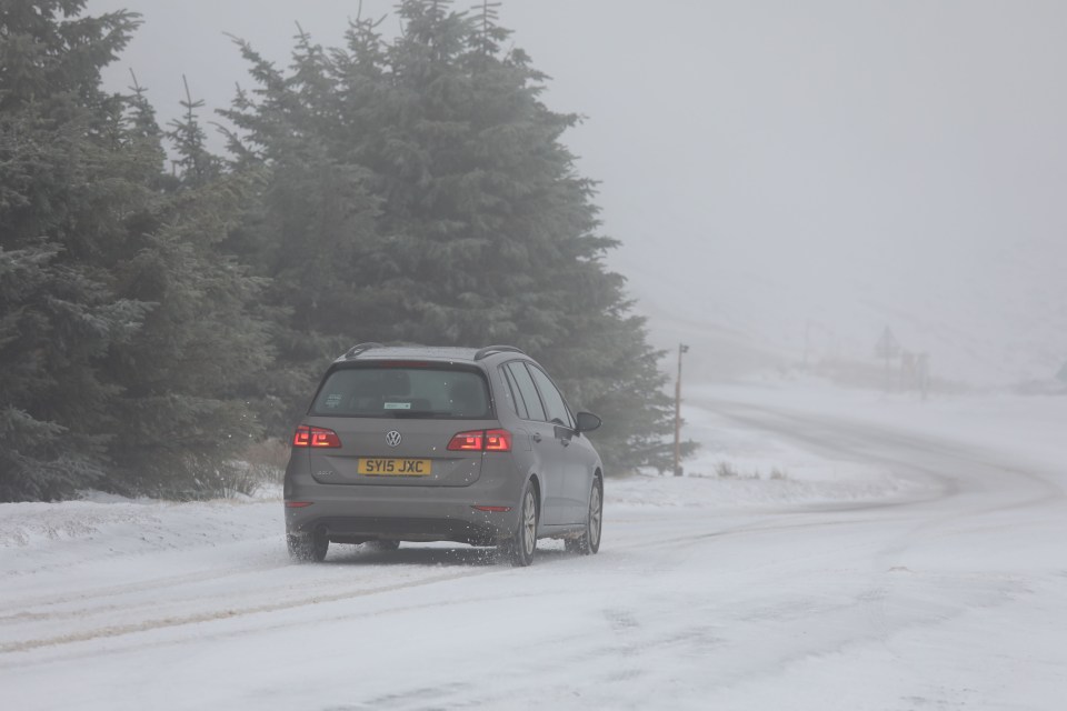 A car struggles through the snow as it hits the Highlands of Scotland today